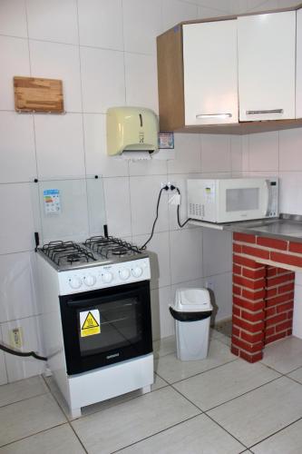 a kitchen with a stove and a microwave at USCEESP Praia Grande in Praia Grande