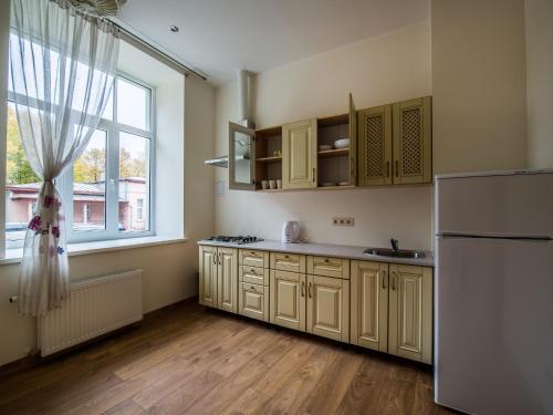 a kitchen with a white refrigerator and a window at AmberHome in Liepāja