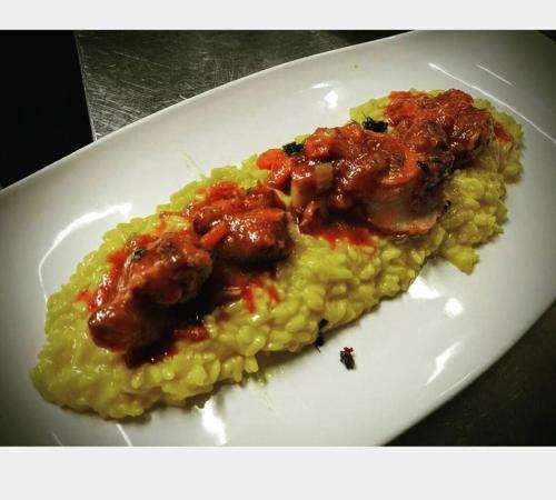 a plate of food with meat and sauce on it at Locanda Dei Nobili Viaggiatori in Cavernago
