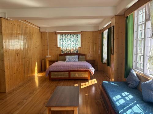 a bedroom with a bed and a couch in a room at Paljor Farm in Ravangla
