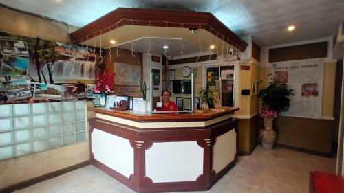 a woman sitting at a counter in a restaurant at Paper Country Inn in Mangagoy