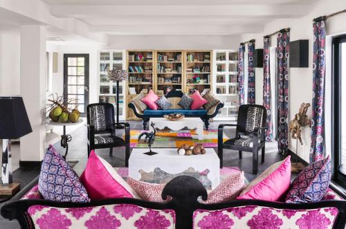 a living room with a couch and pink pillows at Owl and the Pussycat Hotel & Restaurant in Unawatuna