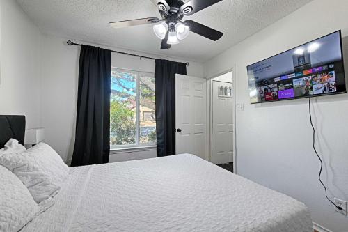 a bedroom with a white bed and a ceiling fan at Little House in the Prairie in Grand Prairie