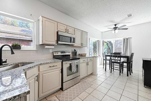 a kitchen with white cabinets and a stove top oven at Little House in the Prairie in Grand Prairie