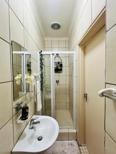 a bathroom with a sink and a shower at Ameni Air B&B in Gqeberha