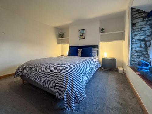 a bedroom with a bed and a stone wall at Arcadia Cottage, Mere in Mere