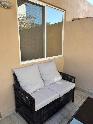 a wicker bench sitting in front of a window at Hermosa casa familiar con terraza comoda in Xochitepec