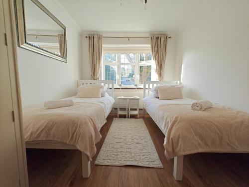 two twin beds in a room with a window at 2 Bed in Brighstone oc-n30464 in Brighstone