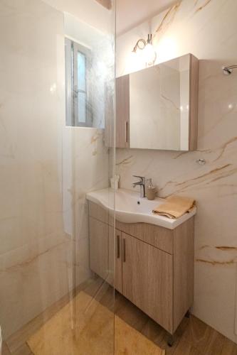 a bathroom with a sink and a shower at Stone house koumani in Thalámai