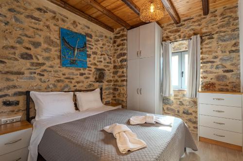 a bedroom with a bed with towels on it at Stone house koumani in Thalámai