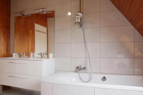 a bathroom with a shower and a tub and a sink at Spacieuse maison avec piscine proche plage à Canca in Cancale