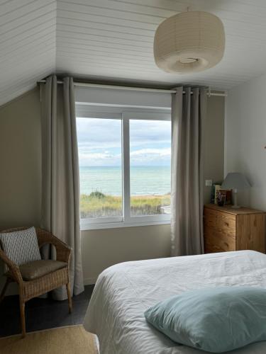 a bedroom with a bed and a large window at Villa Denise Petit Gîte in Barneville-Carteret