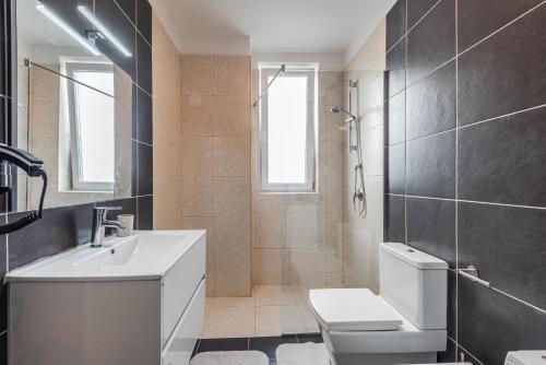 a bathroom with a white sink and a toilet at Blue Haven Talea by PikHost in Tale