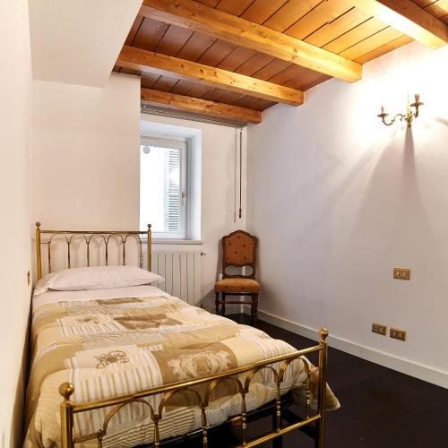 a bedroom with a bed and a chair at P&P Piazza Bergamo Apartment in Bergamo