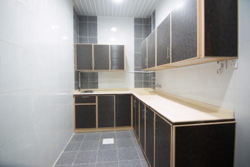 a kitchen with wooden cabinets and a tile floor at Qsr Al Lolo in Sakakah