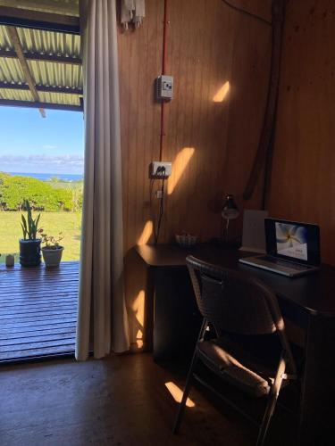 a desk with a laptop and a chair in a room with a window at Studio Sunset Rapa Nui in Hanga Roa