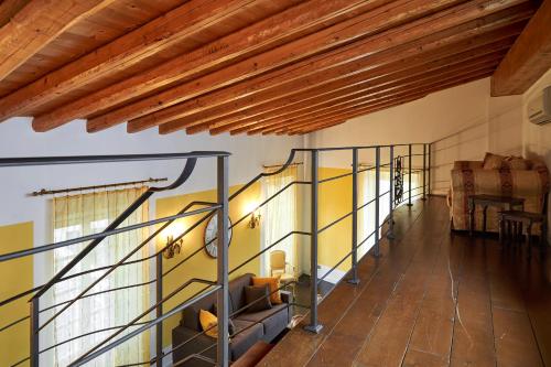 a staircase in a room with yellow walls and wooden ceilings at P&P Piazza Bergamo Apartment in Bergamo