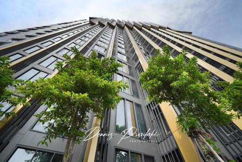 a tall building with trees in front of it at Luxury Edge Seaview Apartment in Pattaya South