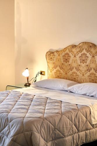a bedroom with a bed and a lamp on a table at P&P Piazza Bergamo Apartment in Bergamo