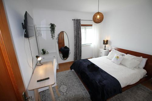 a bedroom with a bed and a table and a mirror at Peniche Surf Lodge 2 in Peniche