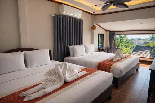 a hotel room with two beds with towels on them at Villa Khili Phousi in Luang Prabang