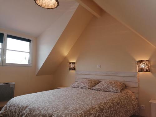 une chambre avec un lit avec deux oreillers dessus dans l'établissement La Quiétude, au Crotoy