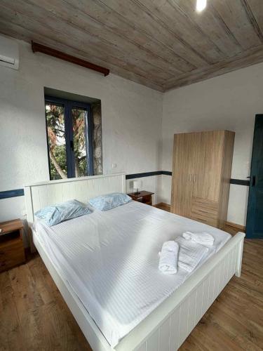 a bedroom with a large white bed with towels on it at Kontias stonehouses in Kondiás