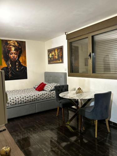 a bedroom with a bed and a table with chairs at Résidence P&C Studio Douillet à Neuilly-sur-Marne in Neuilly-sur-Marne