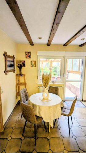 a dining room table with chairs and a vase on it at Movika in Neef