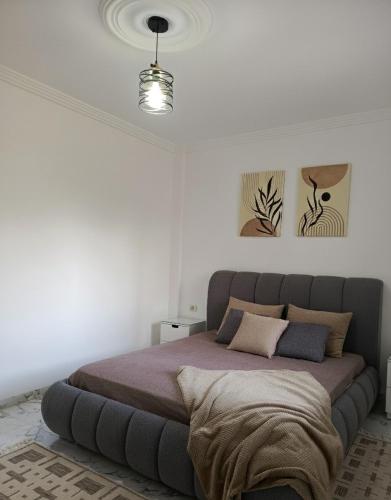 a bedroom with a large bed in a white room at modern apartment in Akouda