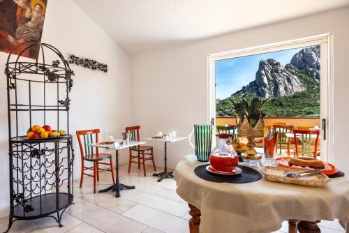 a dining room with a table and a window at Antica Dimora La Corona in San Pantaleo