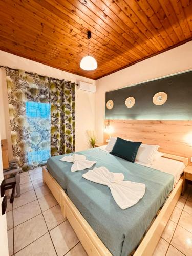 a bedroom with a large bed with a wooden ceiling at Sarita's Apartments & Suite in Laganas