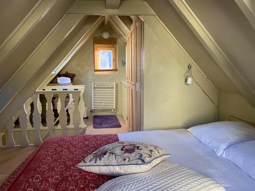 a bed with a pillow in a room with stairs at B&B Herengracht 21 in Amsterdam