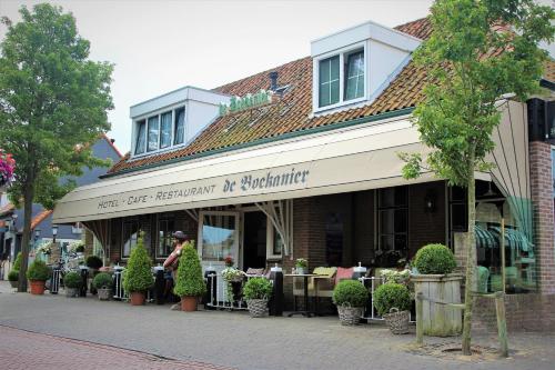 a restaurant with tables and chairs in front of a building at Hotel Restaurant de Boekanier in Vrouwenpolder