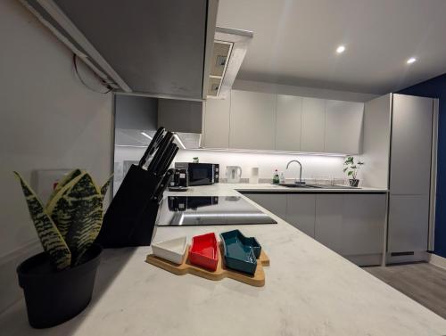 a kitchen with white cabinets and a counter top at Two Bedroom Flat with Ensuite Bathrooms in Hemel Hempstead