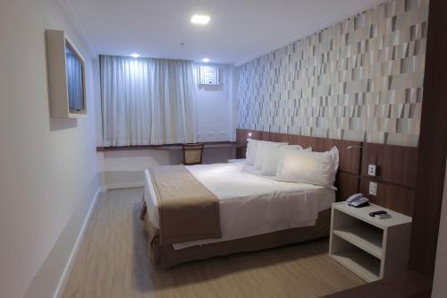 a hotel room with a bed and a television at Casa Nova Hotel in Rio de Janeiro