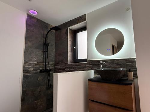a bathroom with a sink and a mirror at Studio avec spa vue Moselle in Dinozé