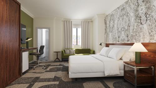 a hotel room with a white bed and a desk at Le Meridien Indianapolis in Indianapolis