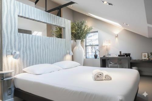 a bedroom with a white bed with towels on it at Fresh Modern Suite, Close to City Hotspots in Oss