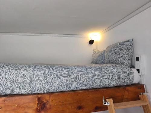a bedroom with a wooden bed with a light on it at Studio lumineux Avignon centre, proche de tout in Avignon
