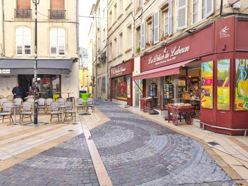 a cobblestone street with tables and chairs and buildings at Studio lumineux Avignon centre, proche de tout in Avignon