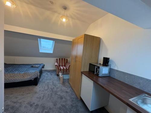 a small room with a bed and a microwave at Spacious Double Room Close to Derby City Centre in Derby