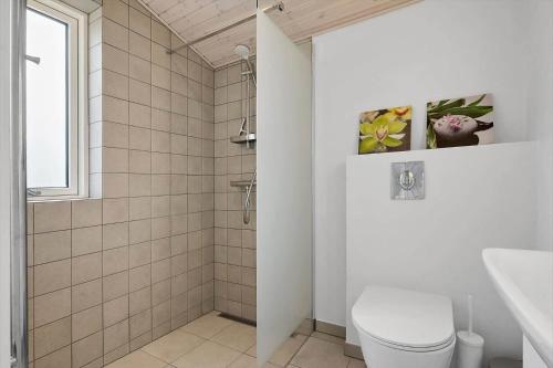 a white bathroom with a toilet and a window at 0186-Romo-Egedesminde-3 in Høm