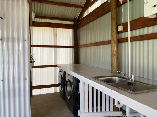 a kitchen with a sink and a washing machine at Eindelik on de Lange in Graskop