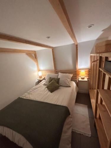 a bedroom with a large bed with two lamps at Le Clos des Eaux in Tailly