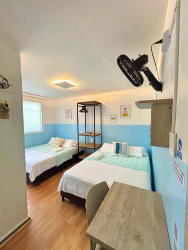 a room with two beds and a table in it at Hotel Anauco in Bucaramanga