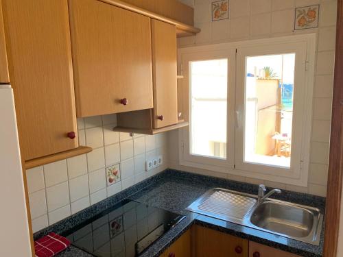 a kitchen with a sink and a window at APT Copacabana-Es Pujols playa in Es Pujols
