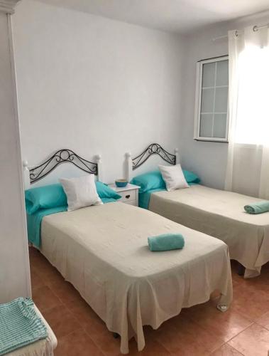 two beds in a room with blue pillows at APT Copacabana-Es Pujols playa in Es Pujols