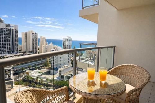 two glasses of orange juice sitting on a table on a balcony at L17 Small Studio Suite 2 Beds Pool Spa in Gold Coast