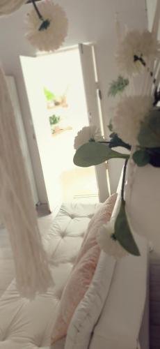 a bedroom with a white bed with flowers on it at Casa das Plantas in Piraju